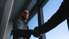 Homem novo moderno elegante com o homem de negócios da barba que agita as mãos com sócio Concluíram um negócio ou um contrato vídeos de arquivo Homem novo moderno elegante com o homem de negócios da barba que agita as mãos com sócio Concluíram um negócio ou um contrato vídeos de arquivo