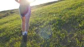 Homem novo que corre sobre o monte verde sobre o fundo do céu azul O atleta masculino está movimentando-se na natureza no por do filme Homem novo que corre sobre o monte verde sobre o fundo do céu azul O atleta masculino está movimentando-se na natureza no por do filme