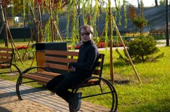 Homem novo que descansa em um parque em um banco após uma corrida imagens de stock royalty free Homem novo que descansa em um parque em um banco após uma corrida imagens de stock royalty free