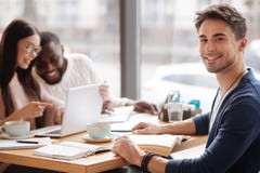 Homem novo que senta-se no café fotografia de stock Homem novo que senta-se no café fotografia de stock