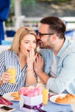 Homem novo que sussurra um segredo a sua amiga fotos de stock Homem novo que sussurra um segredo a sua amiga fotos de stock