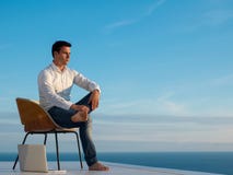 Homem novo relaxado em casa no balcão foto de stock royalty free Homem novo relaxado em casa no balcão foto de stock royalty free