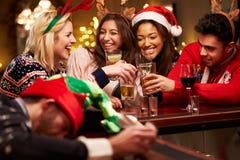 Homem passado para fora na barra durante bebidas do Natal com amigos imagens de stock royalty free Homem passado para fora na barra durante bebidas do Natal com amigos imagens de stock royalty free