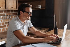 Homem produtivo inteligente que trabalha na cozinha fotografia de stock royalty free Homem produtivo inteligente que trabalha na cozinha fotografia de stock royalty free