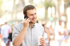 Homem que anda e que fala no telefone celular fotografia de stock royalty free Homem que anda e que fala no telefone celular fotografia de stock royalty free