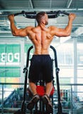 Homem que exercita em uma imprensa do braço em um fundo do gym Equipamento profissional do gym Treinando, exercício, conceito do fotos de stock Homem que exercita em uma imprensa do braço em um fundo do gym Equipamento profissional do gym Treinando, exercício, conceito do fotos de stock