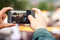 Homem que faz a imagem na rua com telefone celular Fundo do bokeh do festival da rua fotos de stock Homem que faz a imagem na rua com telefone celular Fundo do bokeh do festival da rua fotos de stock