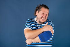 Homem que guarda seu cotovelo dorido Problemas de saúde fotografia de stock royalty free Homem que guarda seu cotovelo dorido Problemas de saúde fotografia de stock royalty free