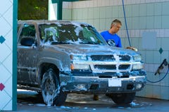 Homem que lava e que esfrega o veículo ensaboado do caminhão imagem de stock Homem que lava e que esfrega o veículo ensaboado do caminhão imagem de stock