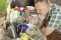 Homem que lava pratos sujos na banca da cozinha imagem de stock royalty free Homem que lava pratos sujos na banca da cozinha imagem de stock royalty free