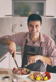 Homem que prepara o alimento na cozinha fotografia de stock Homem que prepara o alimento na cozinha fotografia de stock