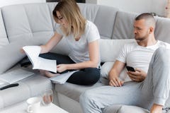 Homem que presta atenção à tevê Mulher que olha através dos originais imagem de stock Homem que presta atenção à tevê Mulher que olha através dos originais imagem de stock