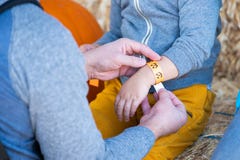 Homem que põe um bracelete de papel sobre a mão dos childs fotos de stock Homem que põe um bracelete de papel sobre a mão dos childs fotos de stock