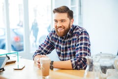 Homem que senta-se na tabela com cappuccino imagens de stock Homem que senta-se na tabela com cappuccino imagens de stock