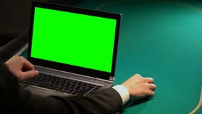 Homem que usa serviços de aposta em linha no portátil, guardando a microplaqueta afortunada, tela verde video estoque Homem que usa serviços de aposta em linha no portátil, guardando a microplaqueta afortunada, tela verde video estoque