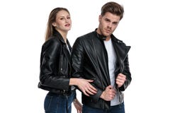 Homem seguro que arrangeing seu revestimento e que levanta com sua amiga foto de stock Homem seguro que arrangeing seu revestimento e que levanta com sua amiga foto de stock