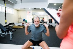Homem superior no gym que dá certo com pesos imagens de stock royalty free Homem superior no gym que dá certo com pesos imagens de stock royalty free