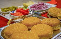 Homemade burger ingredients arranged on tray and plates outdoors. Onion, salted cucumbers, cherry tomatoes, ketchup sauce. stock image Homemade burger ingredients arranged on tray and plates outdoors. Onion, salted cucumbers, cherry tomatoes, ketchup sauce. stock image