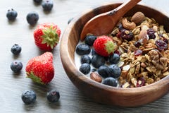 Homemade granola with fresh berry in wooden bowl stock photo Homemade granola with fresh berry in wooden bowl stock photo