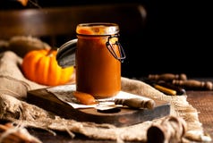 Homemade Sweet And Tasty Pumpkin Caramel N Glass Jar Stands On Wooden Board Stock Photography