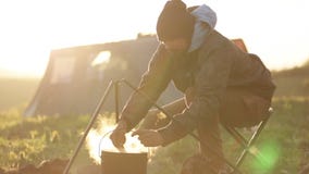 Homens caucasianos que cozinham o alimento no boowler na fogueira no acampamento filme Homens caucasianos que cozinham o alimento no boowler na fogueira no acampamento filme