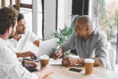 homens de negócios multiculturais que trabalham no portátil e que discutem a estratégia empresarial imagens de stock homens de negócios multiculturais que trabalham no portátil e que discutem a estratégia empresarial imagens de stock