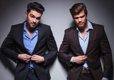 Homens de sorriso da forma que abotoam seus revestimentos fotos de stock Homens de sorriso da forma que abotoam seus revestimentos fotos de stock