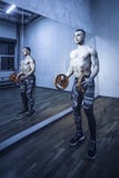 Homens musculares do halterofilista que fazem exercícios no torso despido do gym Imagem tonificada imagem de stock Homens musculares do halterofilista que fazem exercícios no torso despido do gym Imagem tonificada imagem de stock