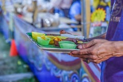Homens que levam amostras de alimento para provar no mercado da noite em Tailândia fotografia de stock royalty free Homens que levam amostras de alimento para provar no mercado da noite em Tailândia fotografia de stock royalty free