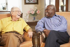 Homens sênior que relaxam nas poltronas imagem de stock royalty free Homens sênior que relaxam nas poltronas imagem de stock royalty free