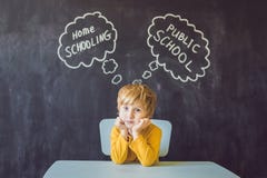 Homeschooling contro le ' public school ' - il ragazzo si siede alla tavola e fotografie stock Homeschooling contro le ' public school ' - il ragazzo si siede alla tavola e fotografie stock