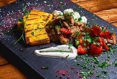Hominy with meat stew pork, beef and salad on a black board. Restaurant menu. Free space for text. royalty free stock photography Hominy with meat stew pork, beef and salad on a black board. Restaurant menu. Free space for text. royalty free stock photography
