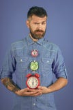 Homme avec le réveil de prise de barbe photo stock Homme avec le réveil de prise de barbe photo stock