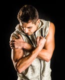 Homme convenable de jeunes fléchissant son biceps d'isolement sur le fond noir images stock Homme convenable de jeunes fléchissant son biceps d'isolement sur le fond noir images stock