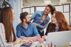 Homme d'affaires avec les collègues féminins heureux au bureau photographie stock Homme d'affaires avec les collègues féminins heureux au bureau photographie stock