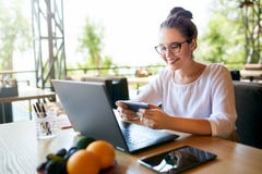 Homme d'affaires bel distrait du travail sur la vidéo de observation d'ordinateur portable sur le smartphone Indépendant tenant l image libre de droits Homme d'affaires bel distrait du travail sur la vidéo de observation d'ordinateur portable sur le smartphone Indépendant tenant l image libre de droits
