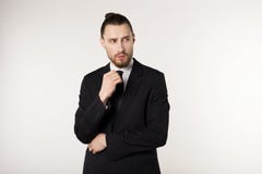 Homme d'affaires bel portant le costume noir et lien semblant soumis à une contrainte et nerveux avec la main près du visage photo libre de droits Homme d'affaires bel portant le costume noir et lien semblant soumis à une contrainte et nerveux avec la main près du visage photo libre de droits