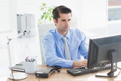 Homme d'affaires concentré dactylographiant sur le clavier images libres de droits Homme d'affaires concentré dactylographiant sur le clavier images libres de droits