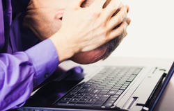 Homme d'affaires frustrant bouleversé devant l'ordinateur portable image stock Homme d'affaires frustrant bouleversé devant l'ordinateur portable image stock