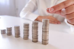 Homme d'affaires plaçant la pièce de monnaie au-dessus de la pile croissante de pièces de monnaie photos libres de droits Homme d'affaires plaçant la pièce de monnaie au-dessus de la pile croissante de pièces de monnaie photos libres de droits
