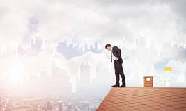 Homme d'affaires regardant vers le bas du toit et du paysage urbain moderne le fond Media mélangé Photographie stock Homme d'affaires regardant vers le bas du toit et du paysage urbain moderne le fond Media mélangé Photographie stock