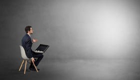 Homme d'affaires restant dans une salle vide avec des substances sur le sien le recouvrement photographie stock Homme d'affaires restant dans une salle vide avec des substances sur le sien le recouvrement photographie stock