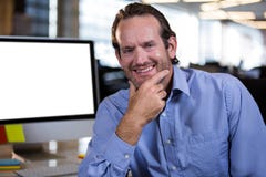 Homme d'affaires sûr avec la main sur le menton dans le bureau Image libre de droits Homme d'affaires sûr avec la main sur le menton dans le bureau Image libre de droits