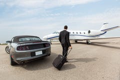 Homme d'affaires Standing By Car et Jet At privée photographie stock libre de droits Homme d'affaires Standing By Car et Jet At privée photographie stock libre de droits
