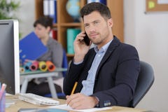 Homme d'affaires sûr avec le téléphone dans le bureau photos libres de droits Homme d'affaires sûr avec le téléphone dans le bureau photos libres de droits