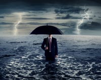 Homme d'affaires tenant le parapluie sur la mer image stock Homme d'affaires tenant le parapluie sur la mer image stock