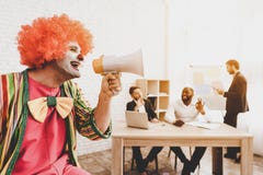 Homme dans le clown Costume avec le haut-parleur dans le bureau photo libre de droits Homme dans le clown Costume avec le haut-parleur dans le bureau photo libre de droits