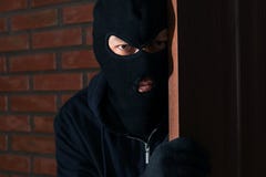 Homme dans le masque remarquant derrière la porte ACTIVIT? CRIMINELLE images stock Homme dans le masque remarquant derrière la porte ACTIVIT? CRIMINELLE images stock
