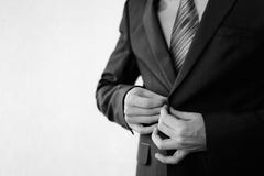 Homme dans un costume noir classique avec une position butanier à la fenêtre images stock Homme dans un costume noir classique avec une position butanier à la fenêtre images stock