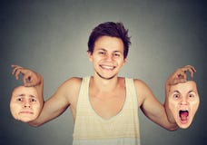 Homme de sourire avec deux masques différents d'émotion photographie stock Homme de sourire avec deux masques différents d'émotion photographie stock